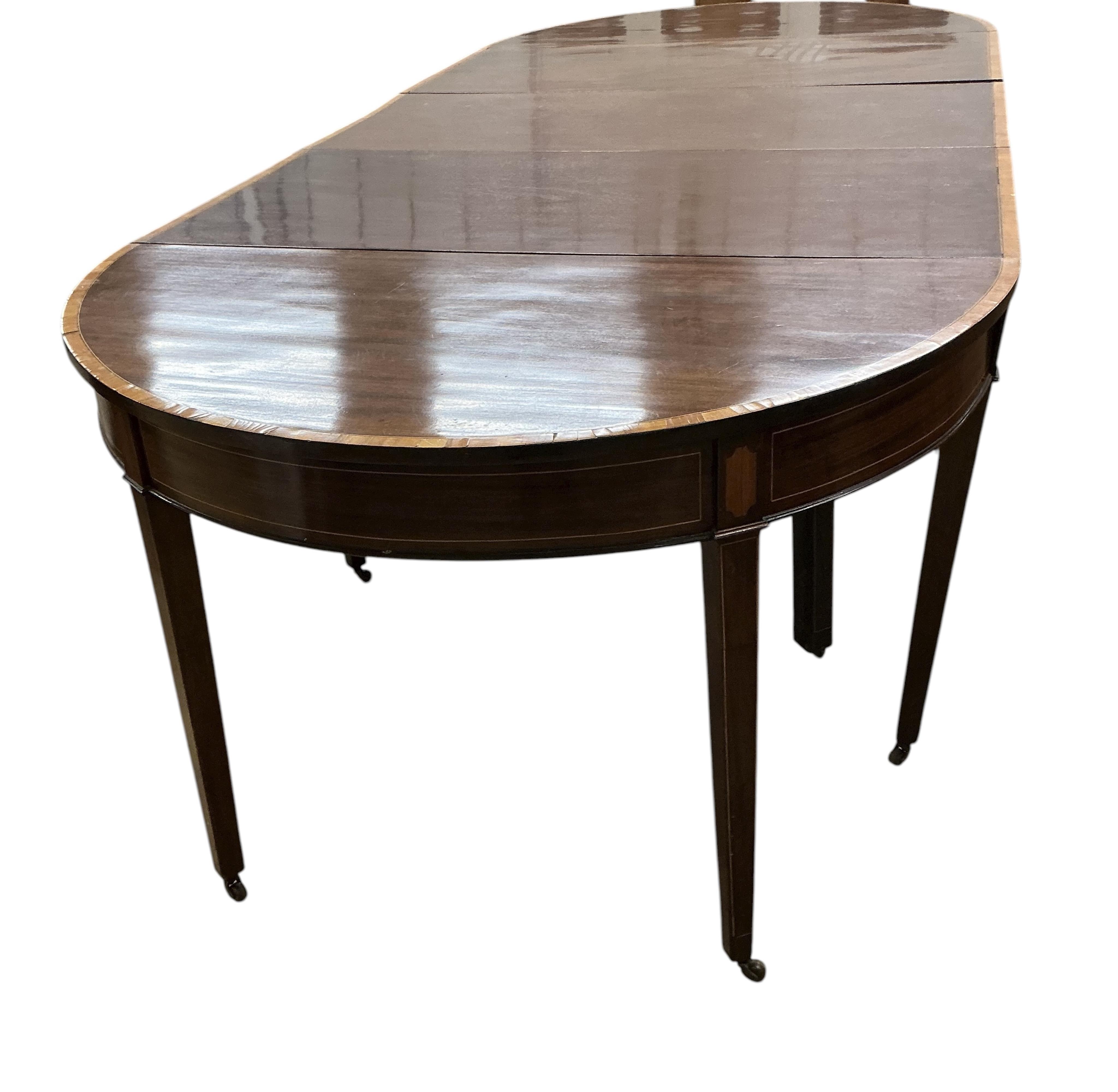 A George III satinwood banded mahogany D end extending dining table, with two spare leaves, 284cm extended, depth 120cm, height 74cm, together with a set of eight Victorian mahogany balloon back dining chairs